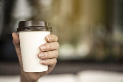 Close-up of hand holding coffee cup