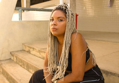 Portrait of young woman sitting on staircase