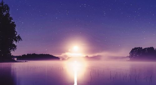 Scenic view of lake against clear sky at night