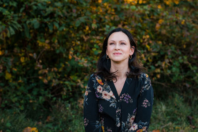 Portrait of smiling young woman standing during autumn