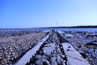 Surface level of railroad track against clear blue sky