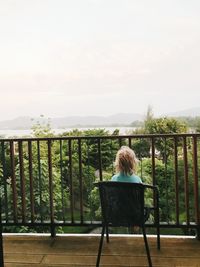 Rear view of woman sitting on bench