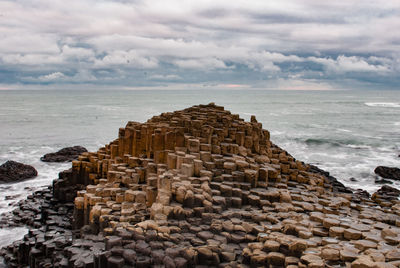 View of rocky beach against clouds