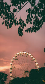 Low angle view of ferris wheel against sky at sunset