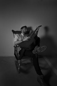 Young man sitting on wall