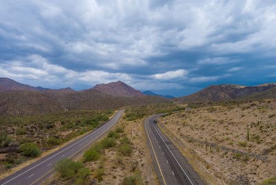 Road leading towards mountains against sky