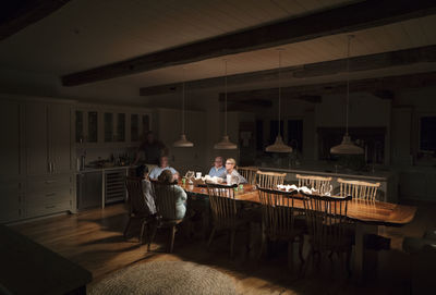 Family sitting at illuminated dining table
