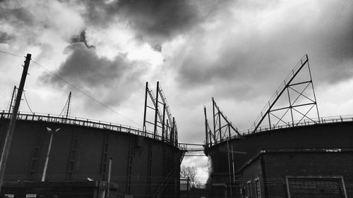 Low angle view of crane against cloudy sky