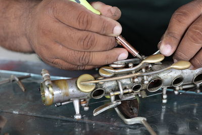 Midsection of man working on metal structure