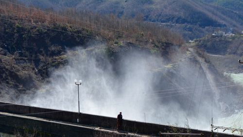 High angle view of man standing on bridge against mountains