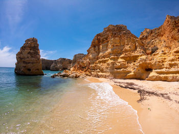 Rock formations in sea against blue sky