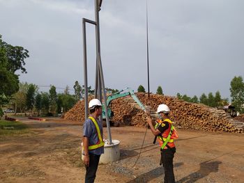 Man working with umbrella against sky