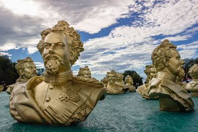 Statue by sea against sky