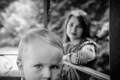 Portrait of cute boy while mother in background