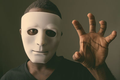 Close-up portrait of man wearing mask gesturing