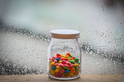 Close-up of multi colored candies in jar on table