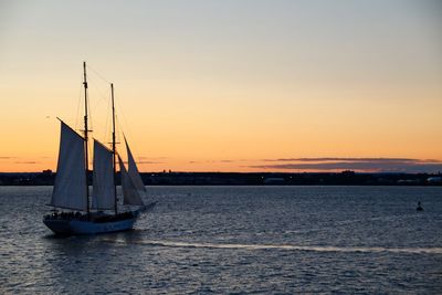 Sailboat sailing on sea against sky during sunset