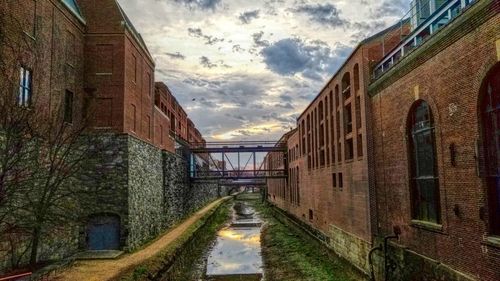 Empty street amidst buildings against sky