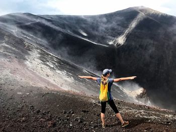 Full length of woman standing on mountain