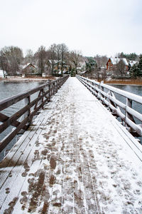 Snow covered footbridge against sky