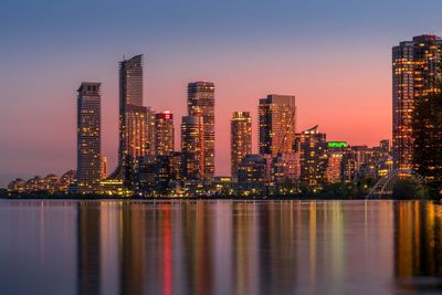 Illuminated buildings against sky at night