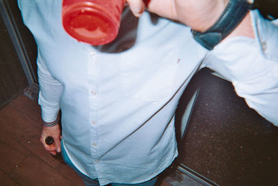 Low section of man standing on bottle