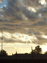 Silhouette of trees against cloudy sky