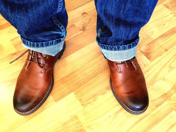 Low section of woman standing on wooden floor
