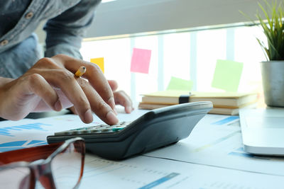 Midsection of man using laptop on table