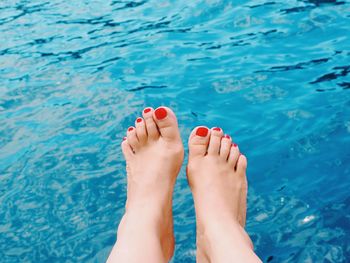 Low section of woman against swimming pool