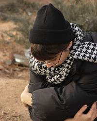 Rear view of woman sitting on field