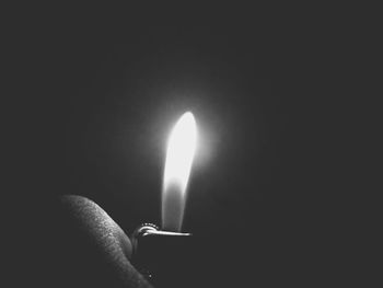 Close-up of burning candle in darkroom