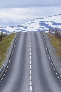 Road by mountain against sky