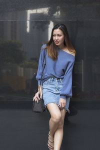 Beautiful woman standing against wall