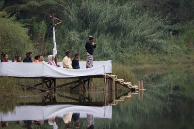 People sitting by lake