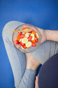 Low section of woman with fruits in bowl