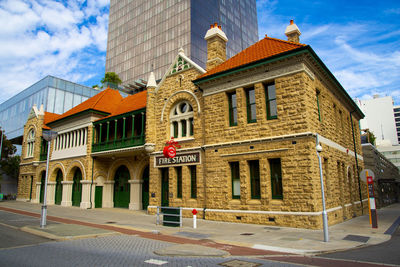 Building by street against sky in city