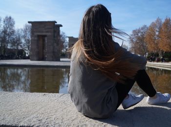 Rear view of young woman with horse in water