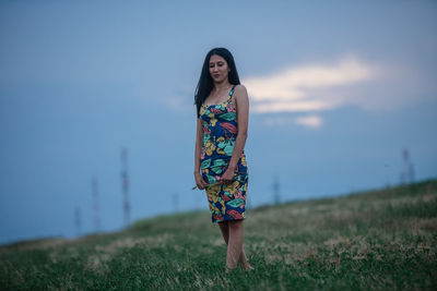 Woman standing on field against sky