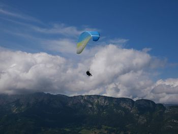 Low angle view of person paragliding against sky