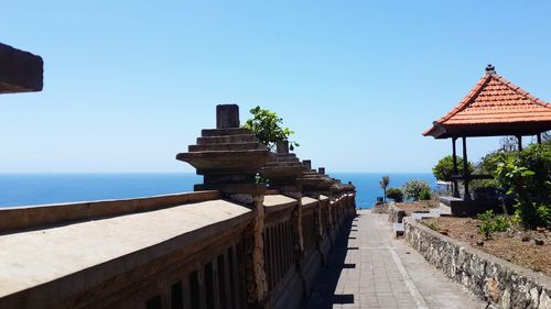 Building by sea against clear blue sky