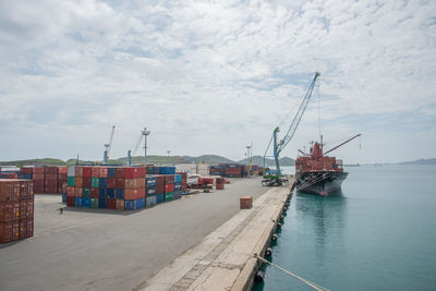 Commercial dock by sea against sky