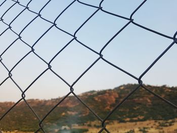 Close-up of chainlink fence against sky