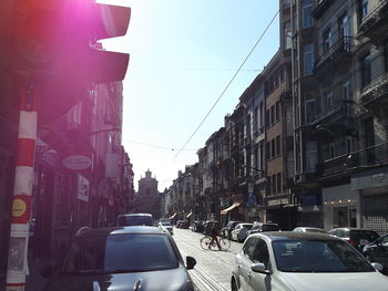 Cars on street in city against sky