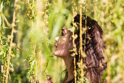 Close-up of young woman amidst plants
