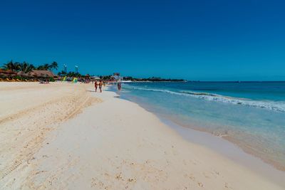 Scenic view of beach against clear blue sky