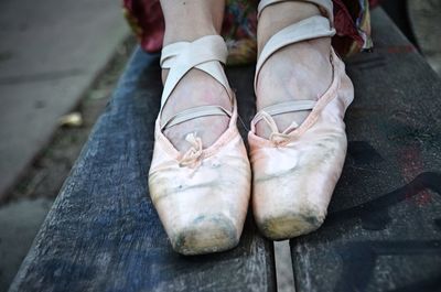 Low section of ballet dancer in show sitting on table