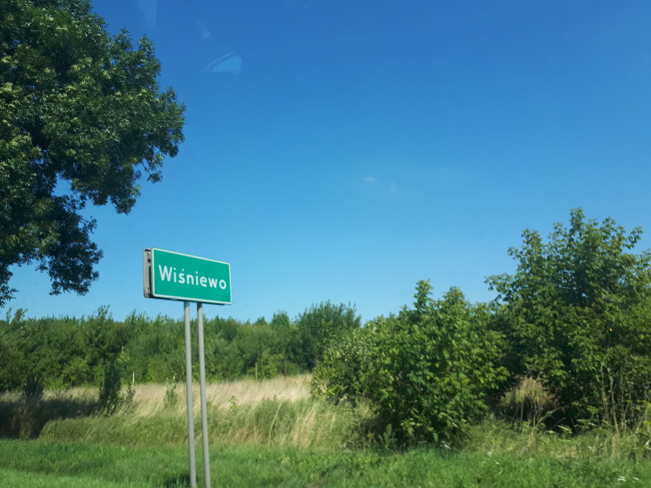 ROAD SIGN ON FIELD AGAINST SKY