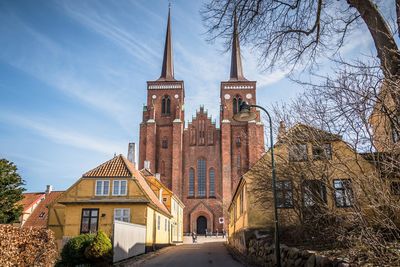 Houses by church against sky