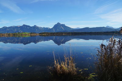 Scenic view of lake and mountains against blue sky